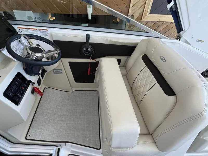 Slide: The Image of 2025 Regal 28X boat interior with steering wheel and plush seating. - 2