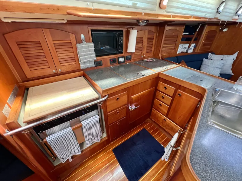 Slide: The Image of 1999 Sabre 402 yacht kitchen with wooden cabinetry, stainless steel sink, and modern appliances. - 10