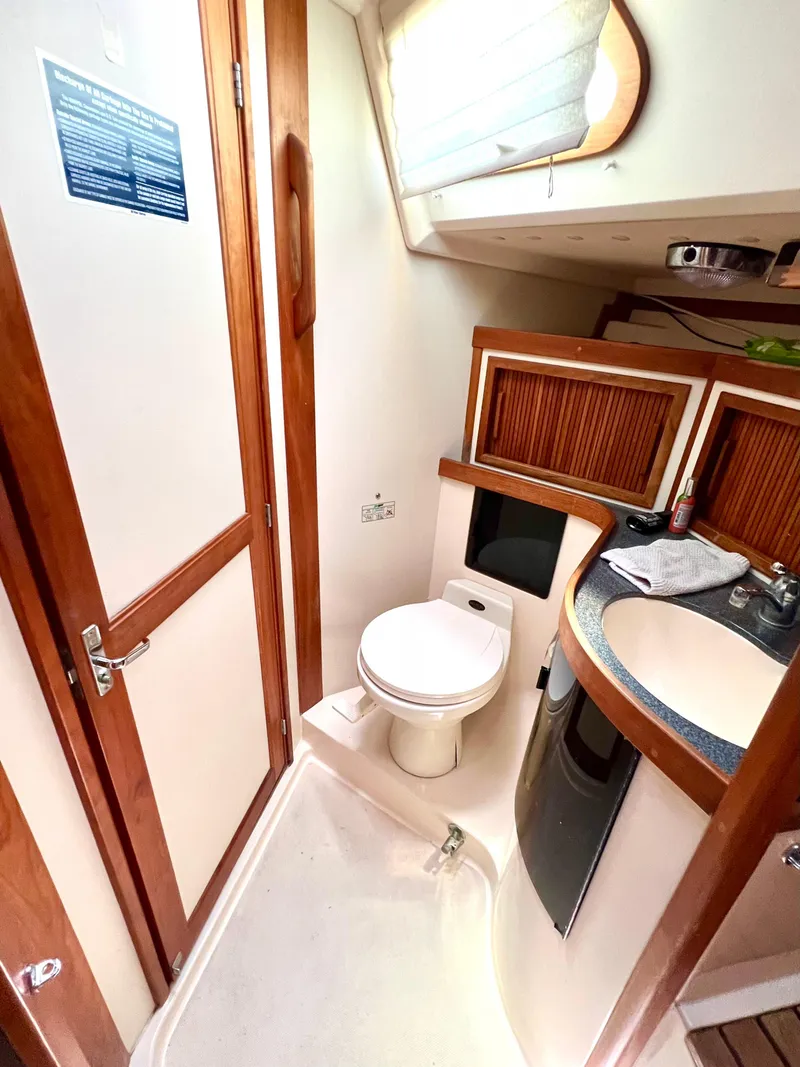 Slide: The Image of 1999 Sabre 402 yacht bathroom with wooden accents and modern fixtures. - 16