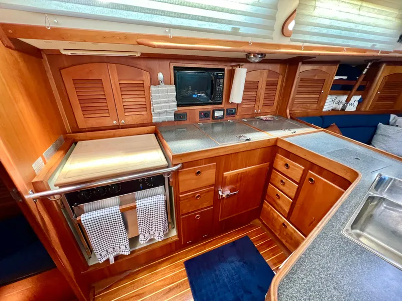 Slide: The Image of 1999 Sabre 402 yacht kitchen with wooden cabinets and modern appliances. - 18