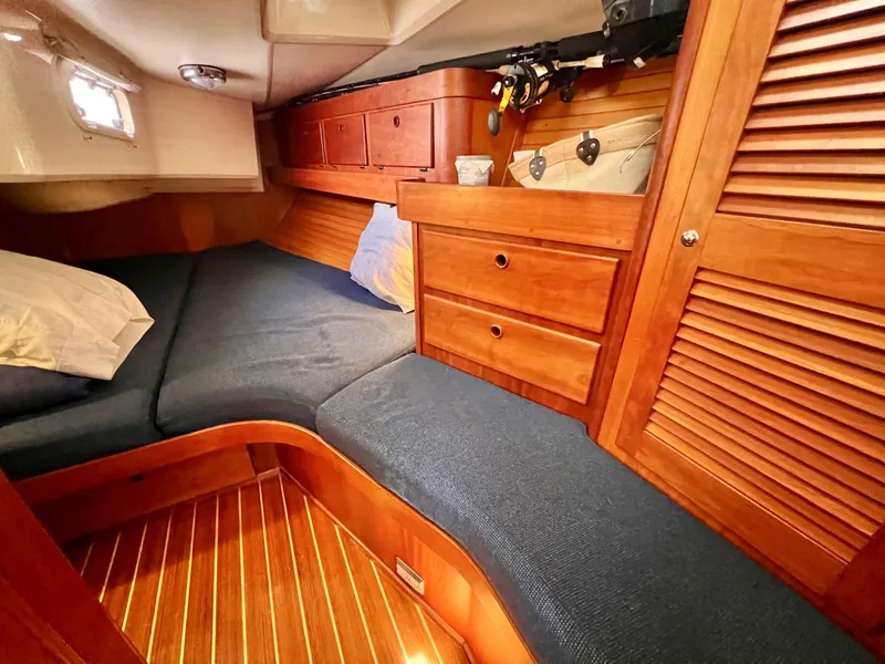 Slide: The Image of 1999 Sabre 402 sailboat interior cabin with wooden cabinetry and blue cushions. - 20
