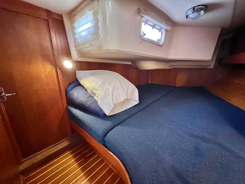 Slide: The Image of 1999 Sabre 402 sailboat cabin with wooden interior and cozy bed. - 21