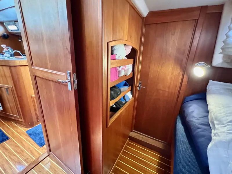 Slide: The Image of 1999 Sabre 402 yacht interior with wooden cabinets and cozy bedroom. - 22