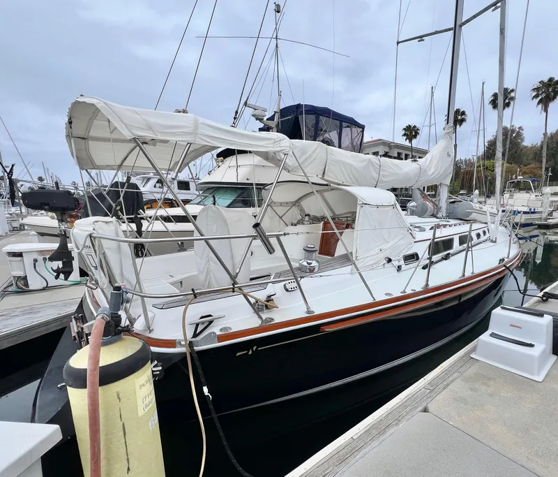 Slide: The Image of 1999 Sabre 402 sailboat docked at marina with white canopy. - 38
