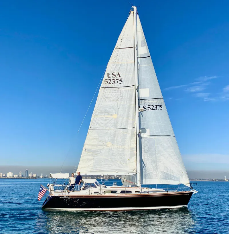 Slide: The Image of 1999 Sabre 402 sailboat on calm waters with city skyline in background. - 45