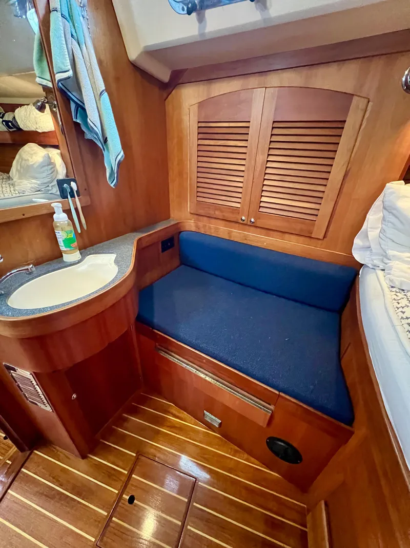 Slide: The Image of 1999 Sabre 402 yacht interior with wooden cabinetry and blue cushioned seating. - 5