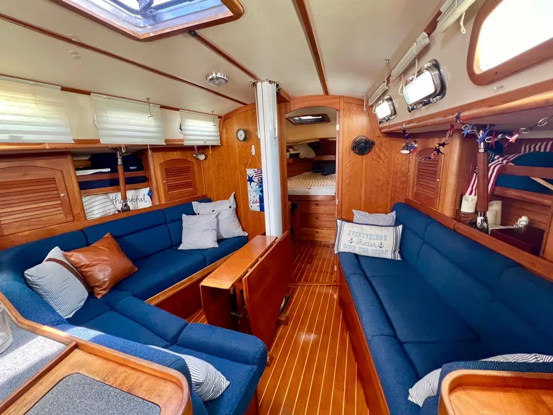 Slide: The Image of Interior of a 1999 Sabre 402 sailboat with blue seating and wooden finishes. - 7
