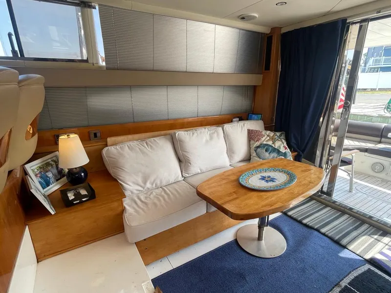 Slide: The Image of Interior of 2001 Viking Princess 45 Flybridge Sport Cruiser with white sofa and wooden table. - 17