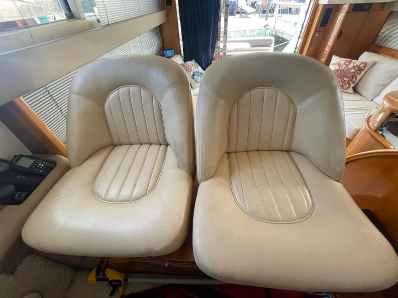 Slide: The Image of Two beige leather seats inside a 2001 Viking Princess 45 Flybridge Sport Cruiser. - 21