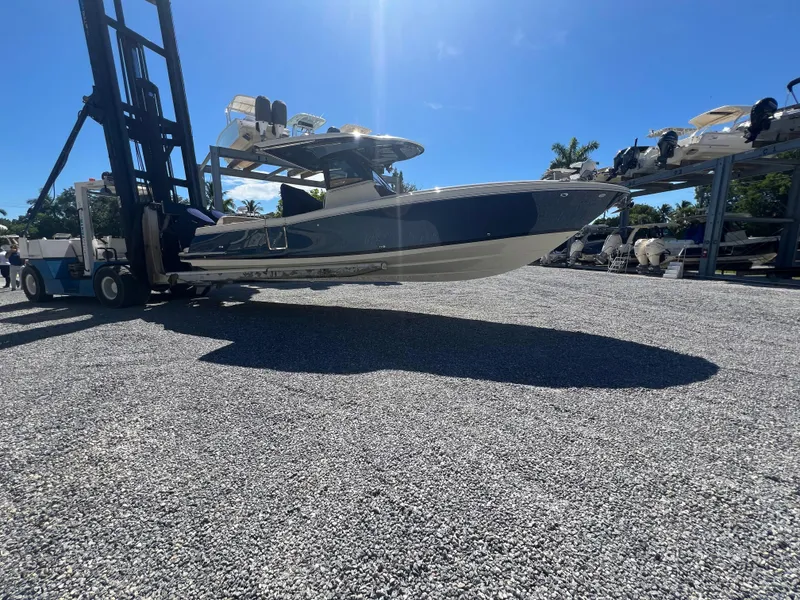 Slide: The Image of 2024 Chris-Craft Catalina 30 boat on a forklift in a marina. - 0