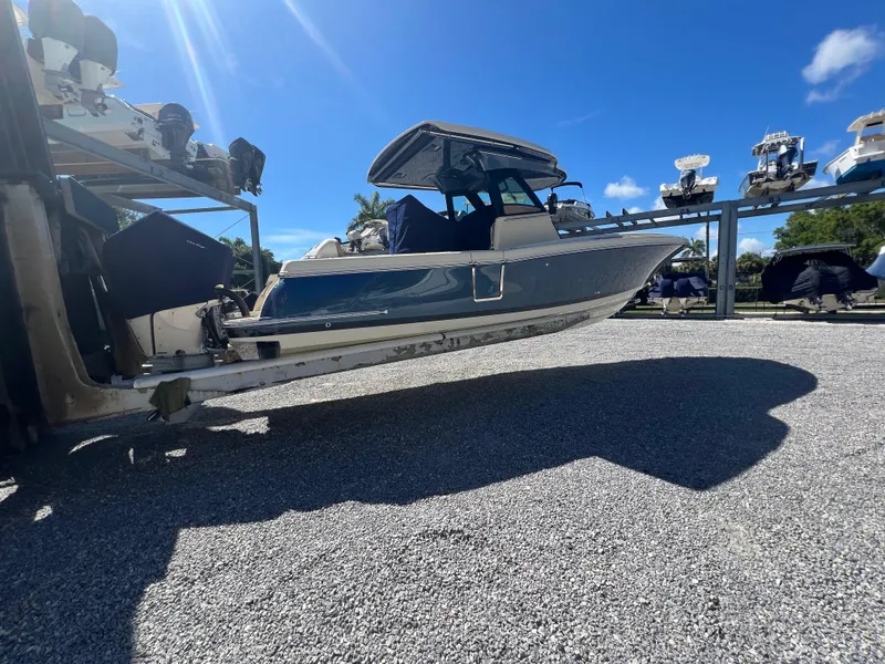 Slide: The Image of 2024 Chris-Craft Catalina 30 boat on a lift under a clear blue sky. - 1