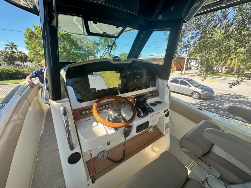 Slide: The Image of 2024 Chris-Craft Catalina 30 helm station with modern navigation equipment and wooden steering wheel. - 10