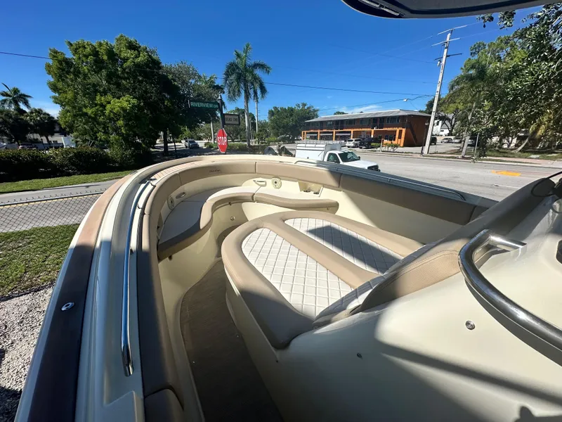 Slide: The Image of 2024 Chris-Craft Catalina 30 boat interior with cushioned seating, docked under clear blue sky. - 13