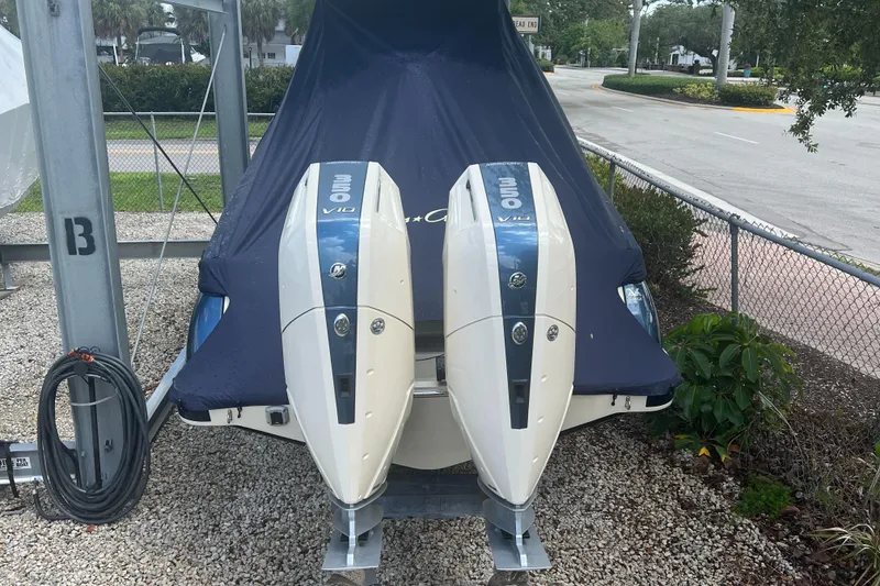 Slide: The Image of 2024 Chris-Craft Catalina 30 with twin outboard engines, covered and parked on gravel. - 5