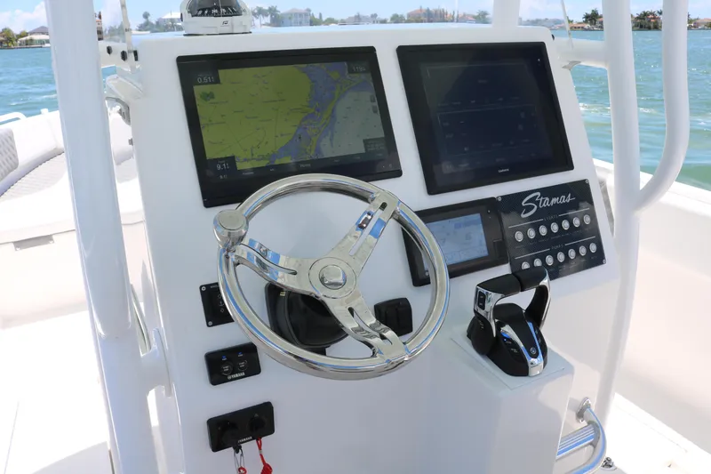 Slide: The Image of 2016 Stamas 317 Tarpon boat dashboard with navigation screens and steering wheel. - 21