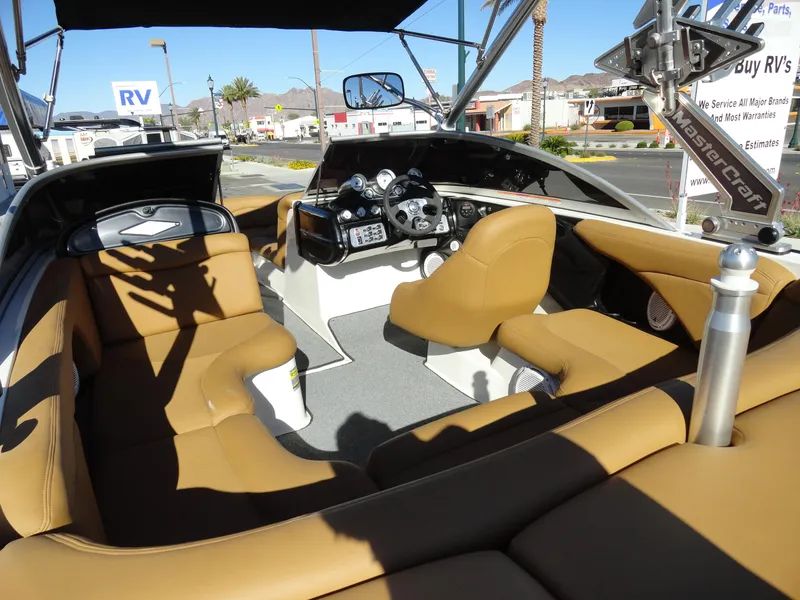 Slide: The Image of 2007 MasterCraft X-Star boat interior with tan seating and modern dashboard. - 7