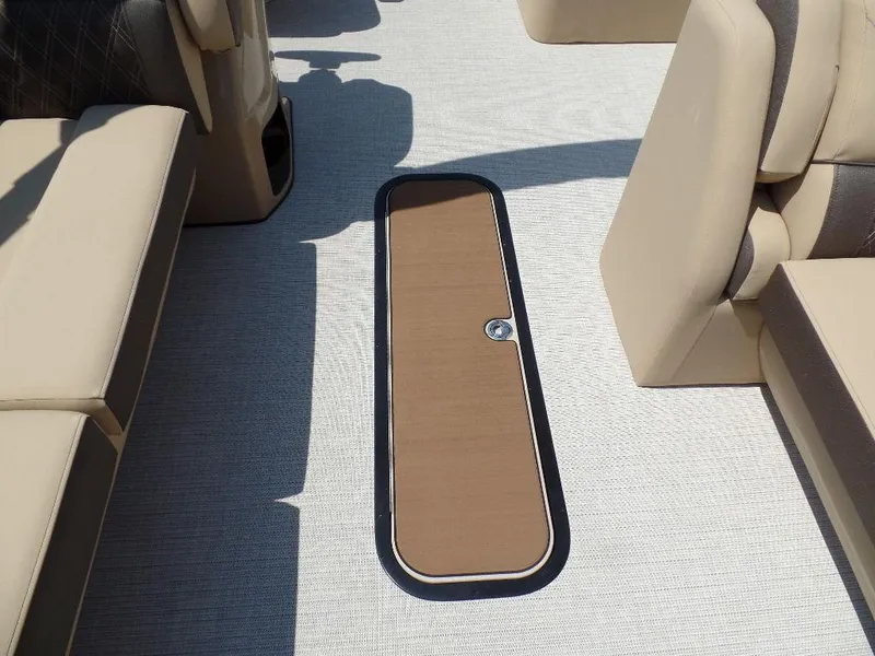 Slide: The Image of 2025 Harris Sunliner 250 boat interior with beige seating and floor storage compartment. - 12