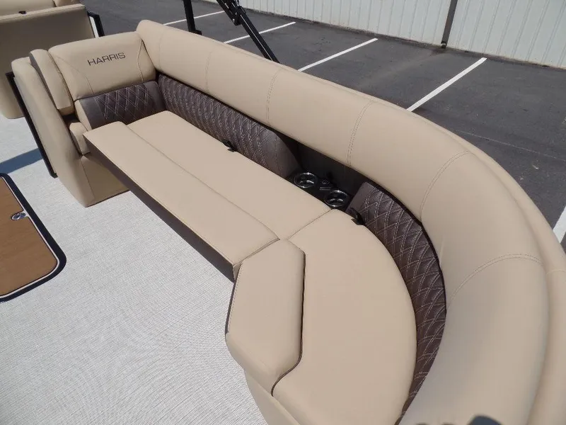 Slide: The Image of 2025 Harris Sunliner 250 boat interior with beige seating and cup holders. - 4