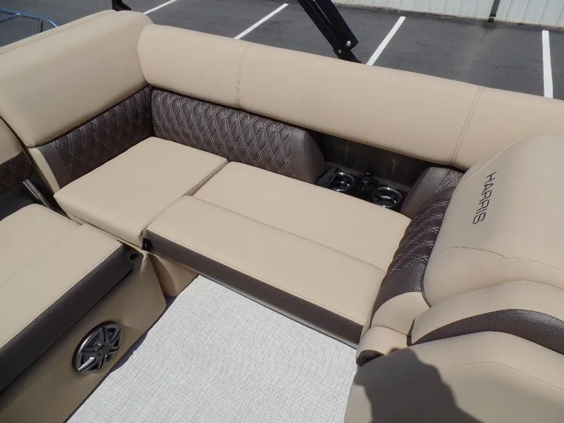 Slide: The Image of 2025 Harris Sunliner 250 boat interior with beige seating and cup holders. - 7
