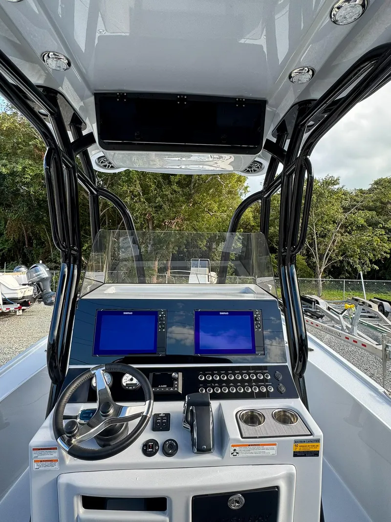 Slide: The Image of 2025 Blazer 2700 HYBRID BAY boat console with dual screens and steering wheel. - 10