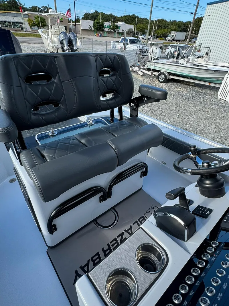 Slide: The Image of 2025 Blazer 2700 HYBRID BAY boat interior with dual seats and steering console. - 12