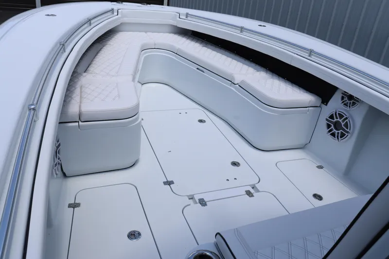 Slide: The Image of 2025 Yellowfin 32 Offshore boat interior with white cushioned seating and storage compartments. - 17