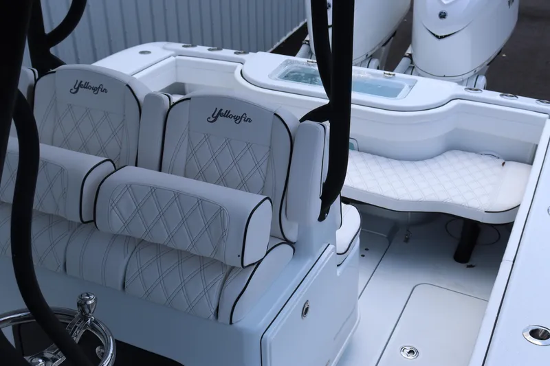 Slide: The Image of 2025 Yellowfin 32 Offshore boat interior with white cushioned seating. - 9