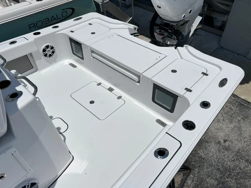 Slide: The Image of 2024 Sportsman Masters 267OE Bay Boat deck with storage compartments and rod holders. - 11