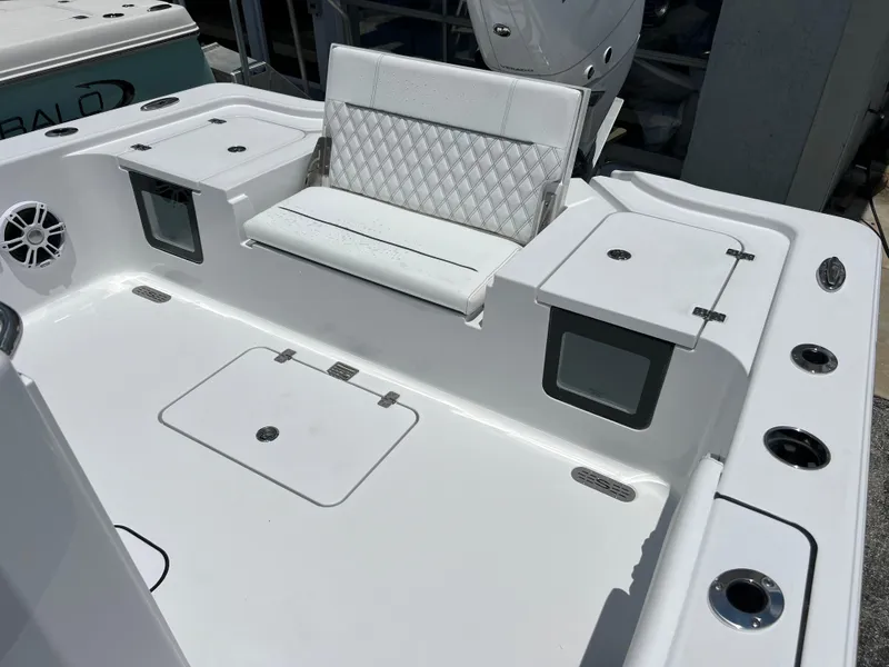Slide: The Image of 2024 Sportsman Masters 267OE Bay Boat, white seating and storage compartments. - 12