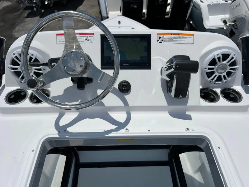Slide: The Image of 2024 Sportsman Masters 267OE Bay Boat dashboard with steering wheel, controls, and display. - 14