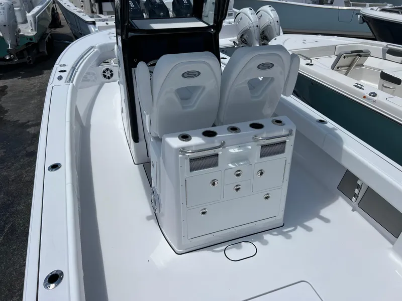 Slide: The Image of 2024 Sportsman Masters 267OE Bay Boat interior with dual seats and storage console. - 4
