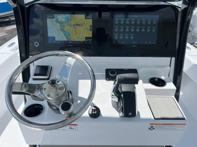 Slide: The Image of 2024 Sportsman Masters 267OE Bay Boat helm with dual displays and stainless steel steering wheel. - 7