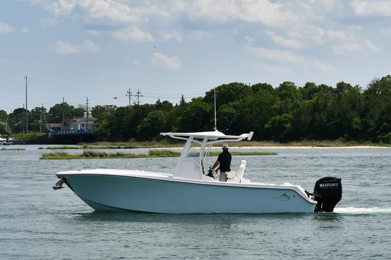 The Image of 2022 Streamline 26CC boat cruising on a scenic waterway with lush greenery. - 0