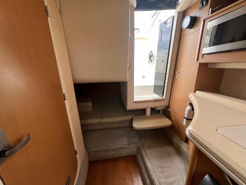 Slide: The Image of Interior of 2009 Sea Ray 270 Sundancer boat, featuring kitchenette and cabin entry. - 12