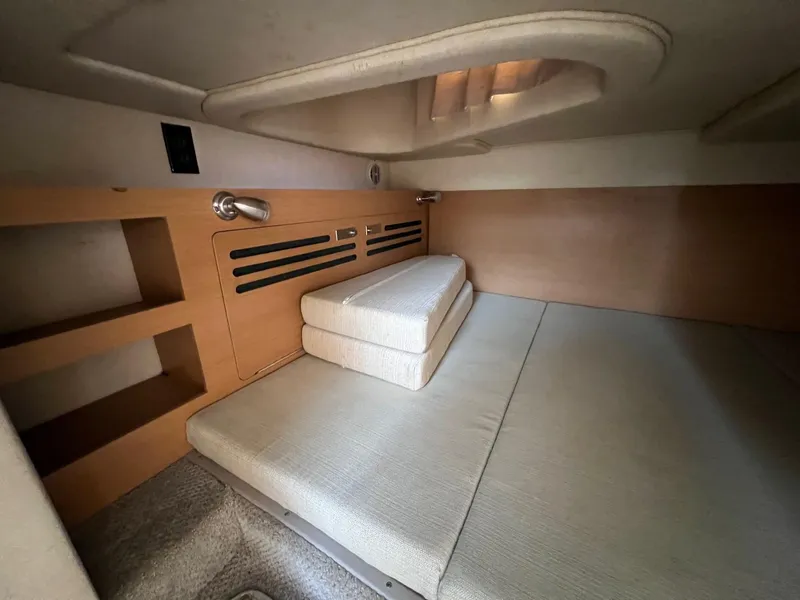 Slide: The Image of Interior cabin of 2009 Sea Ray 270 Sundancer with beige cushions and wooden shelving. - 17