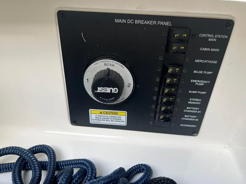 Slide: The Image of Main DC breaker panel on 2009 Sea Ray 270 Sundancer boat with control switches and caution label. - 24