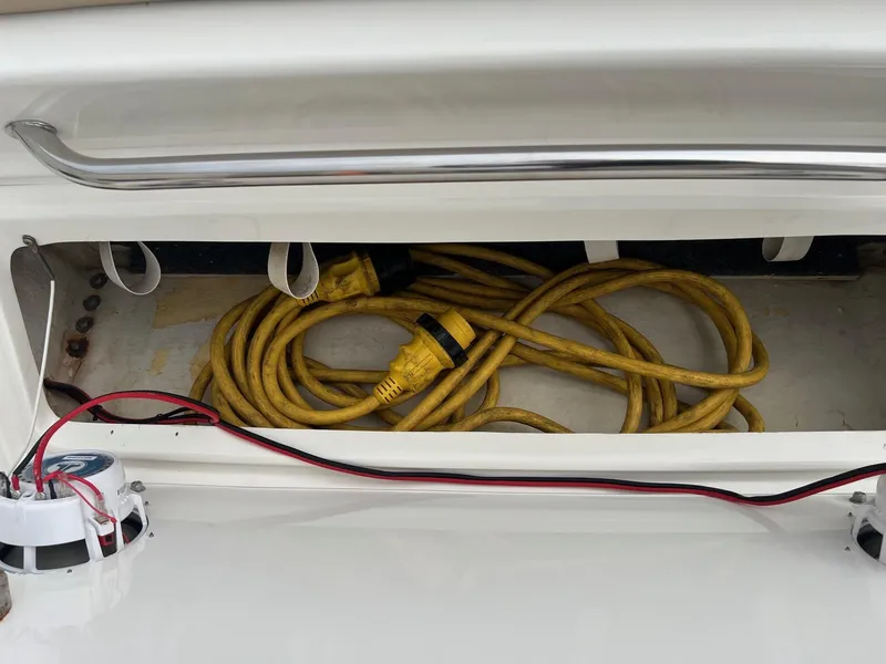 Slide: The Image of Storage compartment with yellow power cables on a 2009 Sea Ray 270 Sundancer boat. - 30