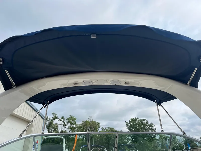 Slide: The Image of 2009 Sea Ray 270 Sundancer boat with blue canopy and clear sky background. - 32