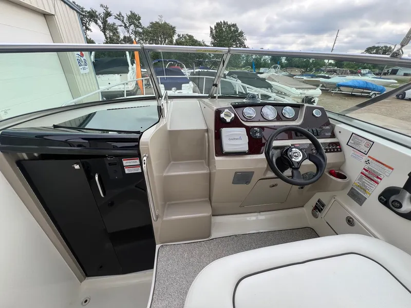 Slide: The Image of 2009 Sea Ray 270 Sundancer cockpit with steering wheel, gauges, and Garmin navigation system. - 8