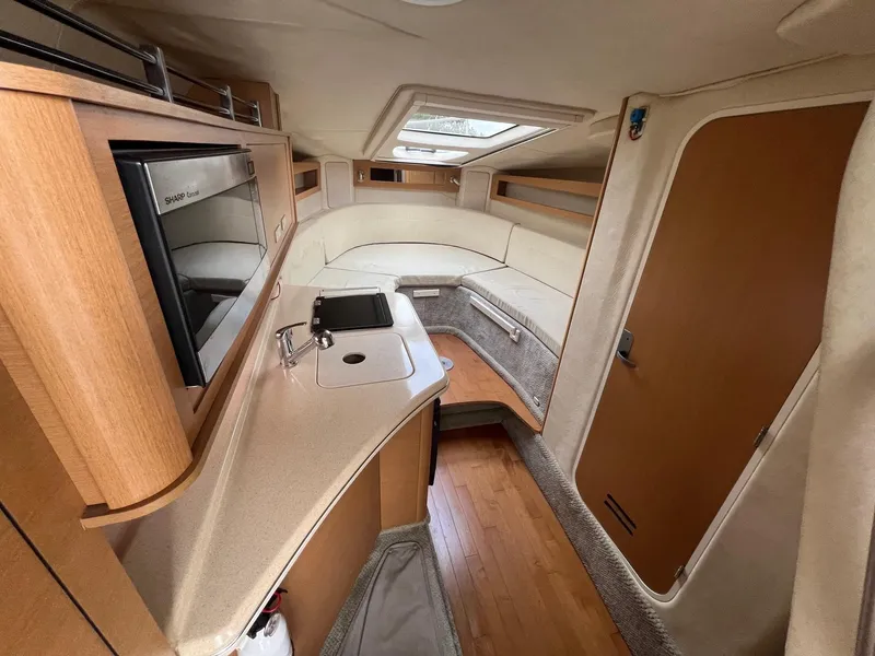 Slide: The Image of 2009 Sea Ray 270 Sundancer cabin interior with kitchenette and seating area. - 9