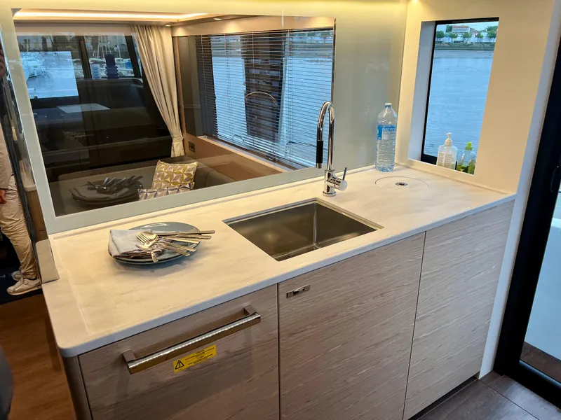 Slide: The Image of Modern kitchen area in 2025 Beneteau Swift Trawler 54 yacht with sink and window view. - 10
