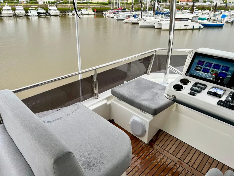 Slide: The Image of Flybridge of 2025 Beneteau Swift Trawler 54 with seating and navigation controls. - 23