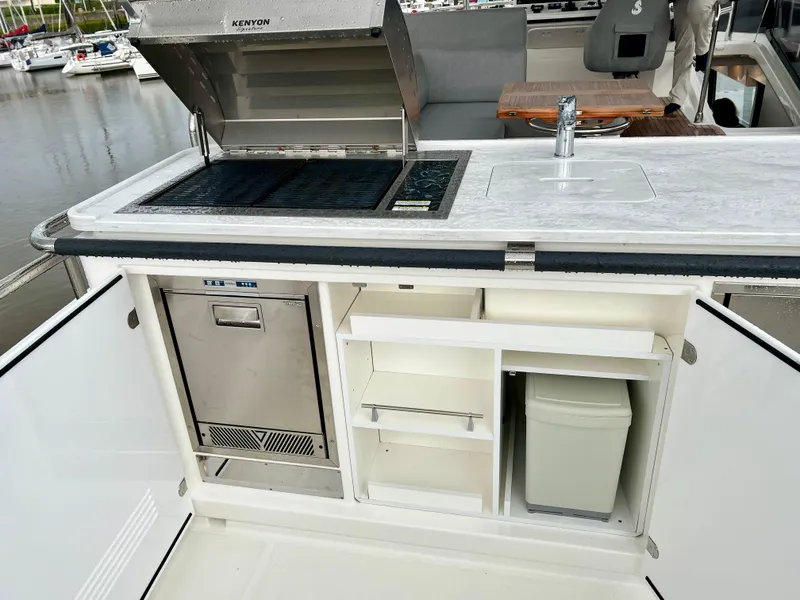 Slide: The Image of Outdoor kitchen on 2025 Beneteau Swift Trawler 54 with grill, sink, and storage. - 26