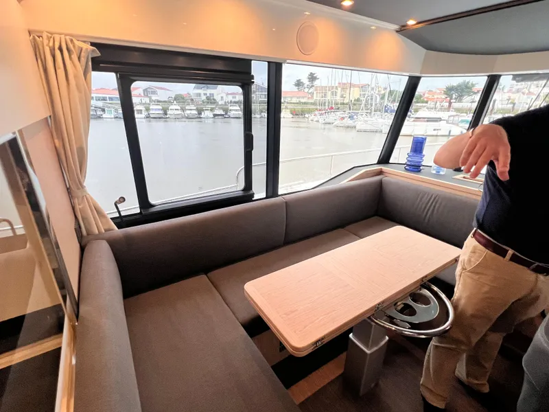 Slide: The Image of Interior seating area of 2025 Beneteau Swift Trawler 54 with waterfront view. - 4