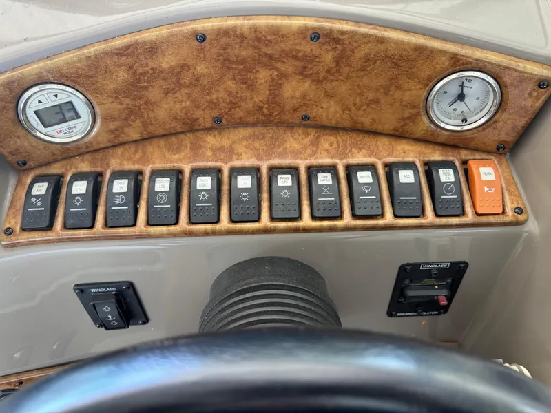 Slide: The Image of Control panel of a 2008 Rinker 370 boat with switches and gauges. - 14