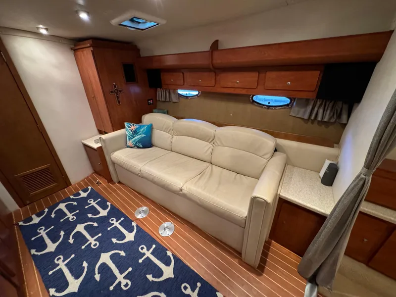 Slide: The Image of Interior of 2008 Rinker 370 yacht with beige sofa and nautical-themed decor. - 20