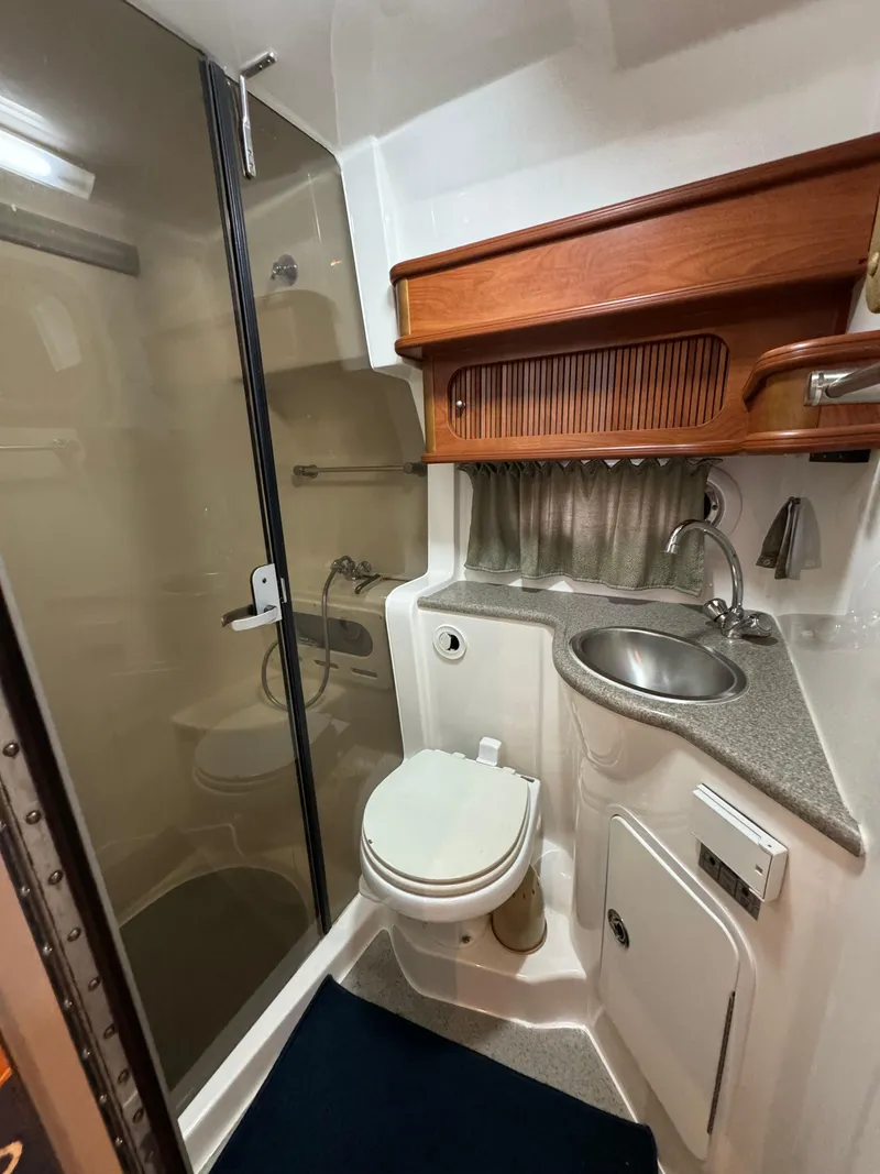 Slide: The Image of 2008 Rinker 370 bathroom with shower, sink, and wooden cabinetry. - 22