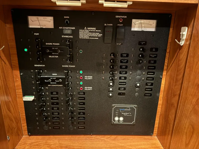 Slide: The Image of Electrical control panel of a 2008 Rinker 370 boat, featuring various switches and gauges. - 25