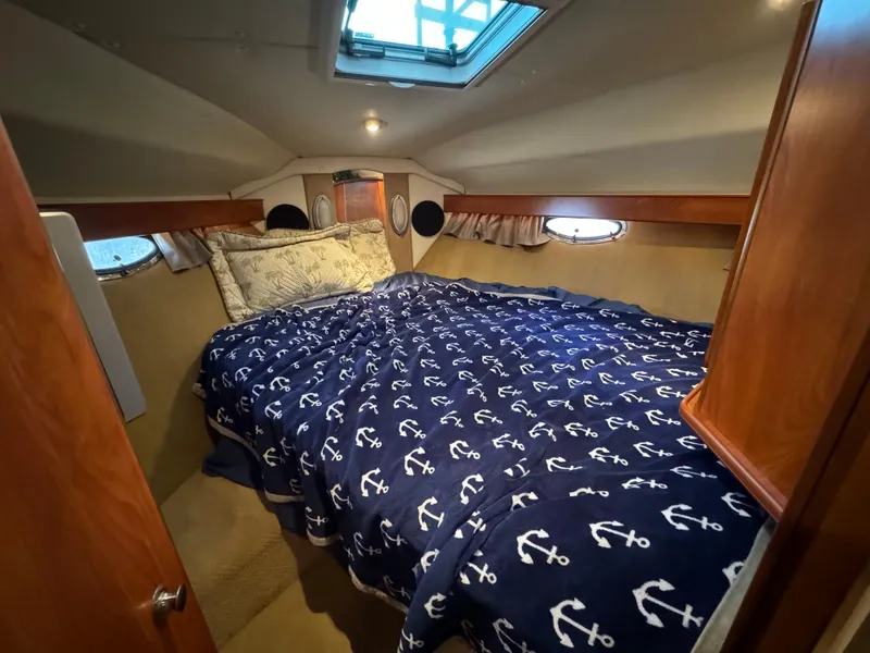 Slide: The Image of Cozy cabin interior of 2008 Rinker 370 with nautical-themed bedding. - 26