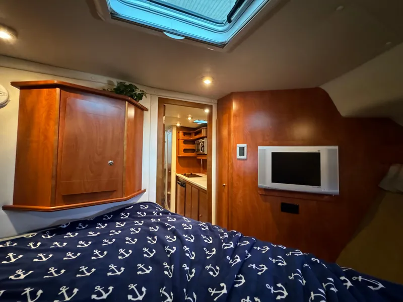 Slide: The Image of Interior of 2008 Rinker 370 boat cabin with TV and nautical bedding. - 27